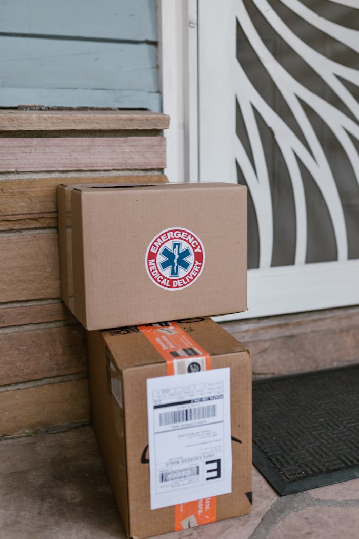 Cardboard boxes with emergency medical delivery labels on a doorstep.